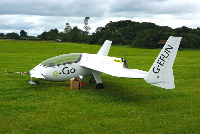 White microlight aircraft parked on grass before take-off