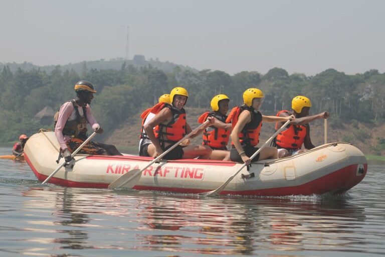 Rafting crew in helmets paddling together